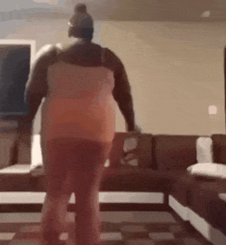 a woman is standing in a living room with a couch .