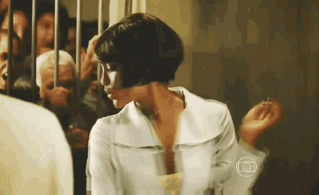 a woman in a white shirt is standing in front of a crowd