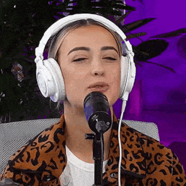 a woman wearing headphones is sitting in front of a microphone .