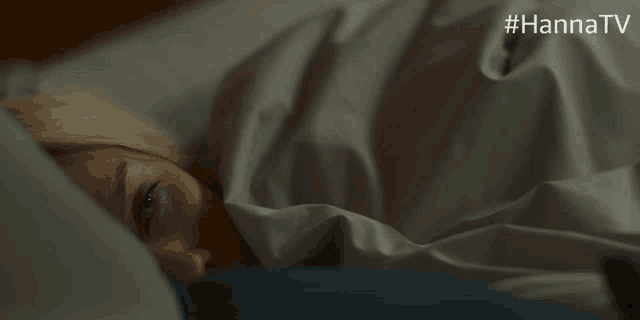 a woman is laying in bed with the hashtag #hannatv on the bottom right