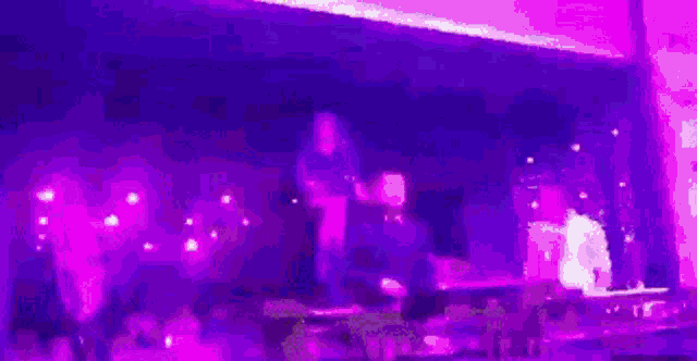 a blurry picture of a man playing a keyboard and a woman dancing on stage