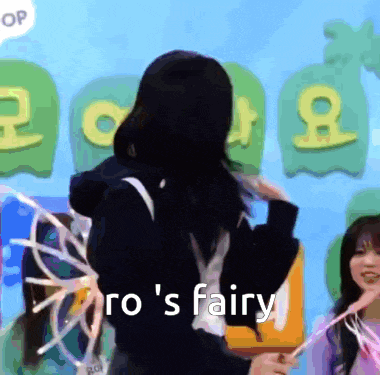 a girl is standing in front of a sign that says ro 's fairy .