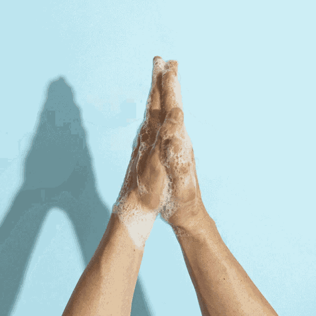 a person washing their hands with soap and water