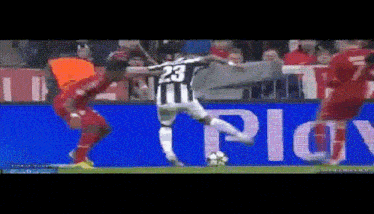 a soccer player with the number 23 on his jersey kicks the ball