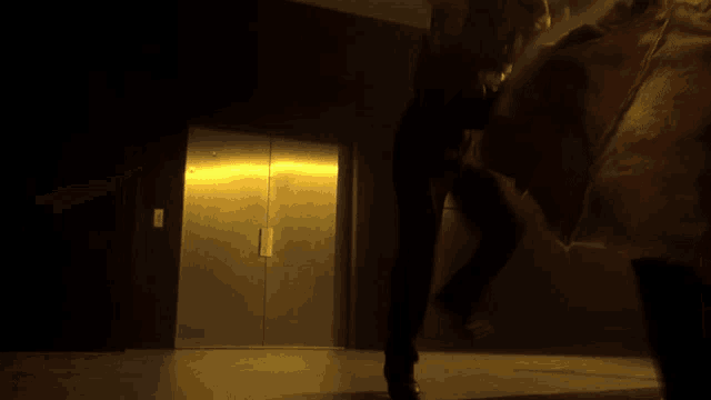 a dark room with a yellow door and a light shining through it