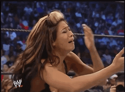 a woman in a wrestling ring with a w logo on the bottom
