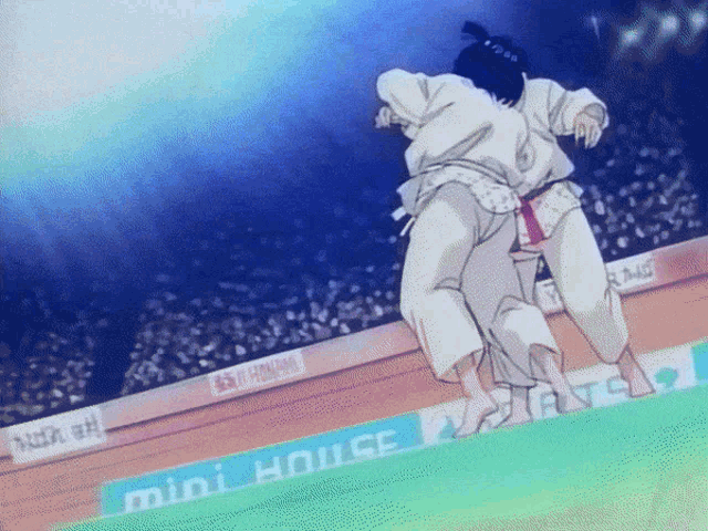 two wrestlers are wrestling in front of a mini house banner
