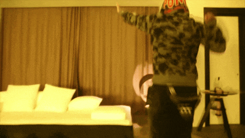 a man in a camo jacket is standing in a room
