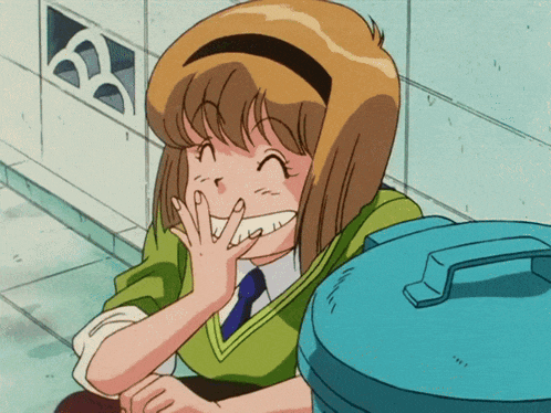 a girl in a green shirt is smiling and covering her mouth