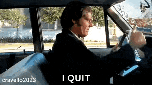 a man in a suit and tie is driving a car and says i quit