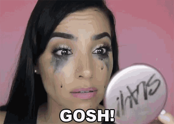 a woman is crying while looking at herself in a mirror with the words gosh written on it