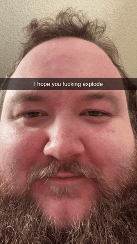 a man with a beard and mustache says i hope you fucking explode on his face