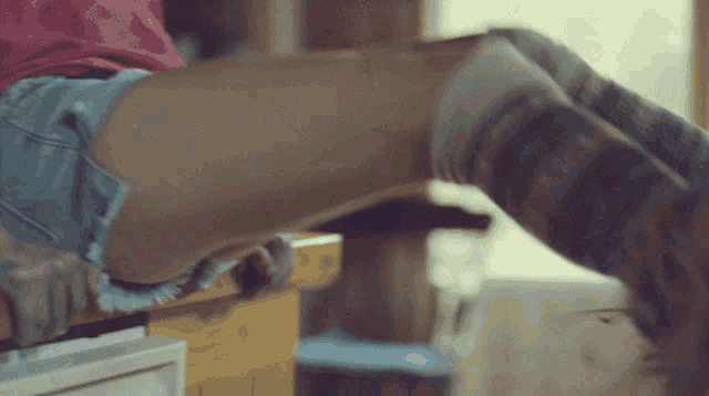 a woman wearing knee high socks and shorts is sitting on a counter