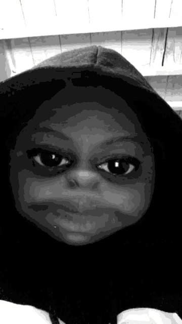a black and white photo of a person wearing a hooded sweatshirt