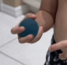 a close up of a person holding a blue ball in their hands .