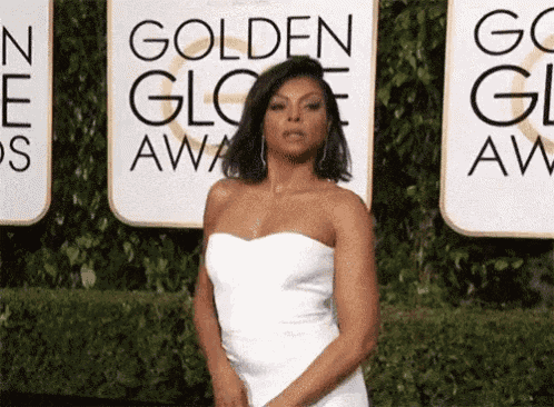 a woman in a white strapless dress is standing in front of a sign that says golden globe awards