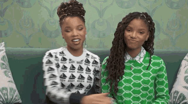 two girls wearing green and white sweaters with boats on them