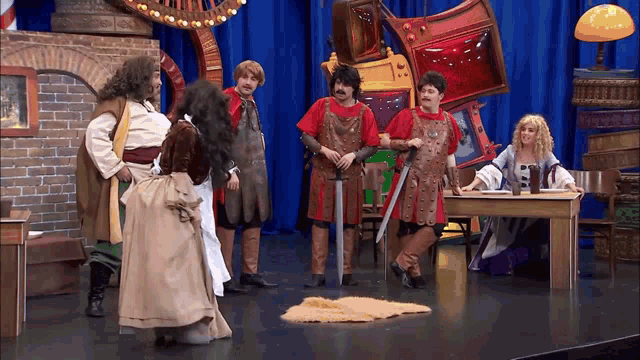 a group of people dressed in medieval costumes are standing around a table