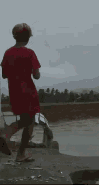 a person in a red shirt is standing on a ledge