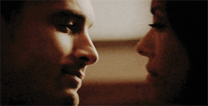 a man and a woman are looking into each others eyes .