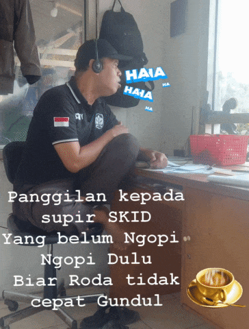 a man wearing headphones sits in front of a desk with a sticker that says haia