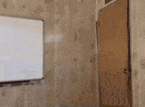 a person is standing in a room with a white board in the background