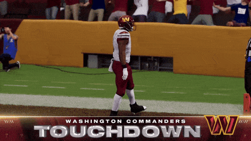 a washington commanders football player is walking on the field
