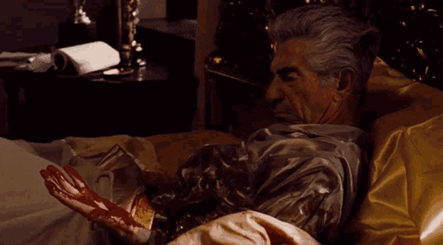 a man laying in bed with a book on the nightstand behind him
