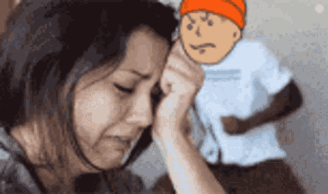a woman is crying in front of a cartoon character