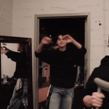 a man in a black sweatshirt is standing in a doorway