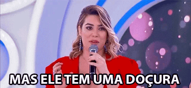 a woman in a red dress is holding a microphone and speaking into it .