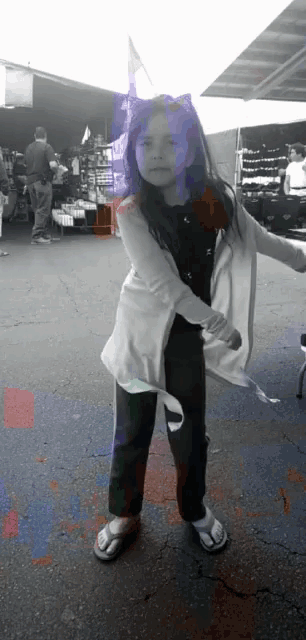 a little girl with purple hair is standing in front of a store