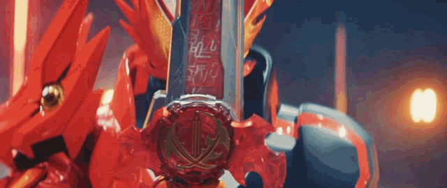 a close up of a red sword with a dragon on it in a dark room .