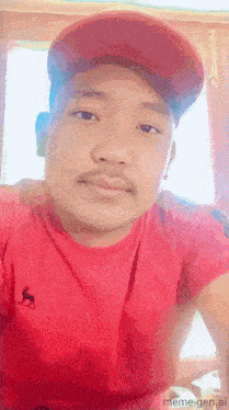 a man wearing a red shirt and a red hat is taking a selfie
