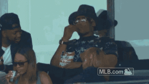 a man sitting in a stadium with a mlb.com logo