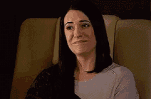 a woman is sitting in a chair and smiling at the camera .