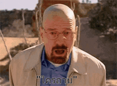 a bald man with glasses and a beard is making a funny face with his mouth open in a foreign language .