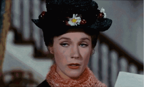 a woman wearing a black top hat with a flower on it