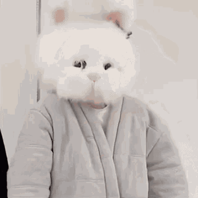 a person wearing a white furry hat with a cat 's face on it .