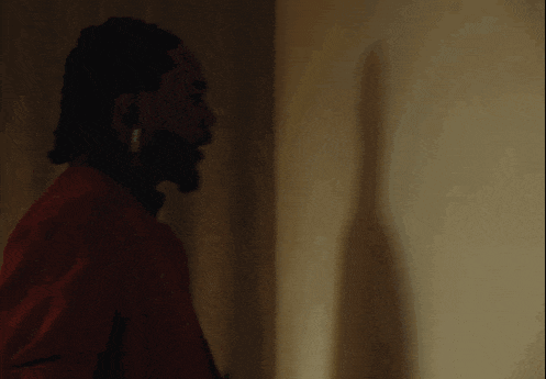 a man with dreadlocks and a beard is wearing ear buds