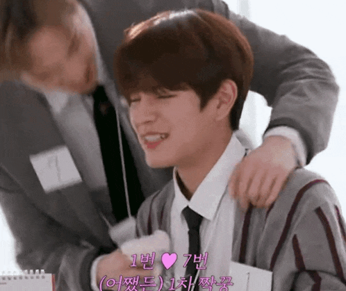 a man in a suit and tie is putting his hand on another man 's shoulder