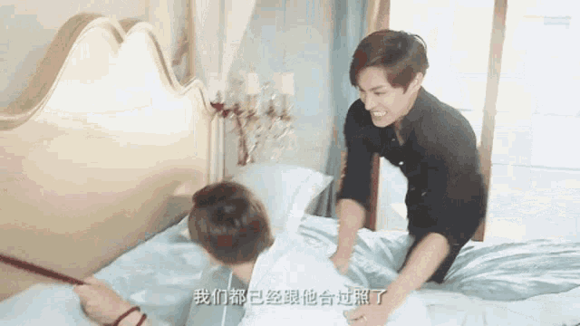 two men are playing on a bed with chinese writing