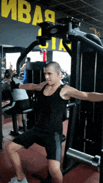 a man is using a machine in a gym under a sign that says " ивая цита "