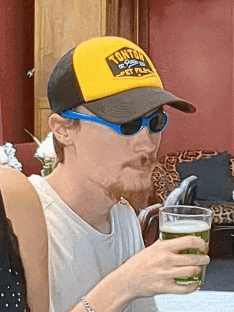a man wearing sunglasses and a hat that says tonton on it