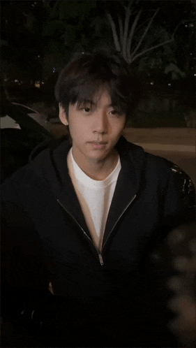 a young man in a black jacket and white shirt