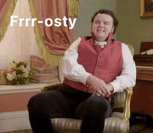 a man in a red vest sits in a chair with the words frrr-osty written above him