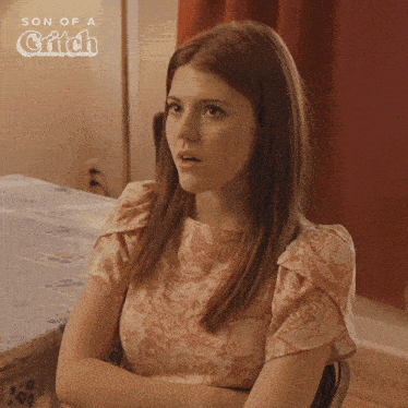 a woman is sitting at a table with her arms crossed and the words son of a critch on the bottom