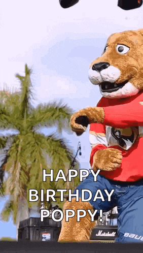 a mascot is standing on a stage and says happy birthday poppy !