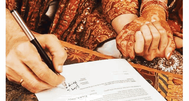 a man is writing on a piece of paper that says " i do " on it