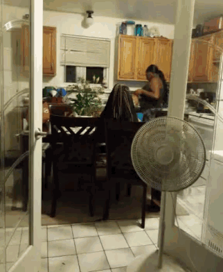 a fan is sitting in a kitchen next to a dining room table
